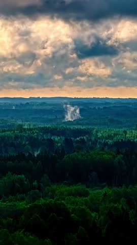 Dramatic clouds over forest, vibrant greenery, peaceful and serene view