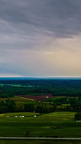A serene countryside timelapse with vast fields under a cloudy sky