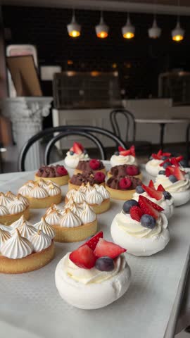 Sweets and pastries on display in a bakery with colorful toppings and fresh fruits