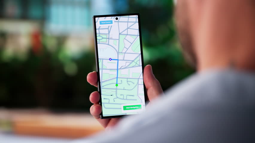 Traveling Businessman Navigating City Streets With GPS On His Phone. Tourist Exploring Urban Area With Electronic Map