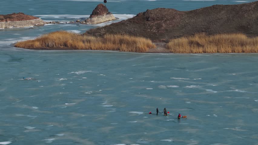 Fishermen on the ice on the lake. Winter time. The view from the drone.