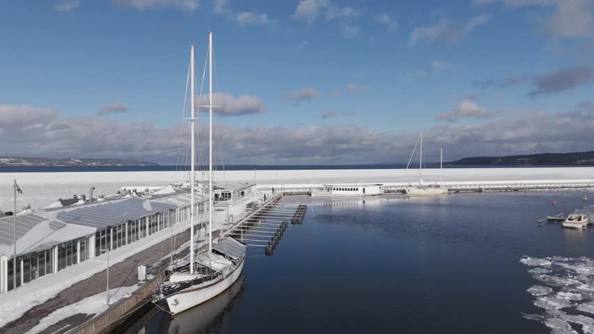 Winter harbor with boats and frozen lake