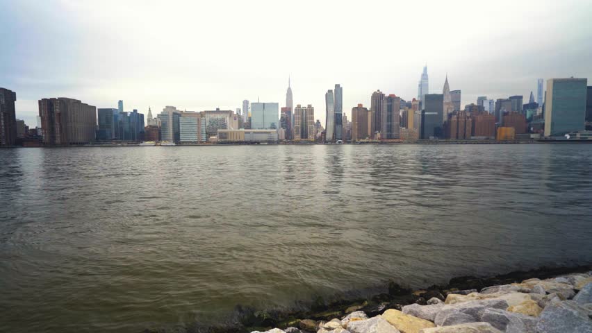 Slow Zoom In On Midtown Manhattan And Empire State Building In Center Frame From Across A River