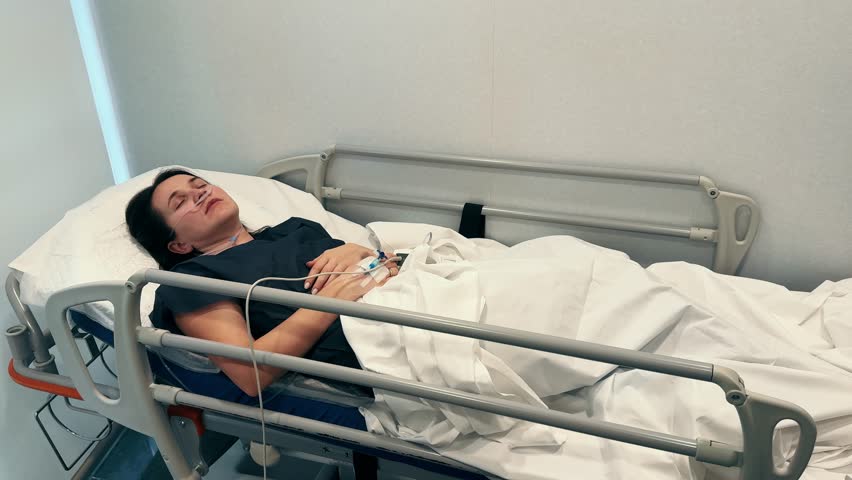 Patient lies in bed in the hospital. Intravenous drip in the hand. Healthcare and medical treatment concept. High quality 4k footage
