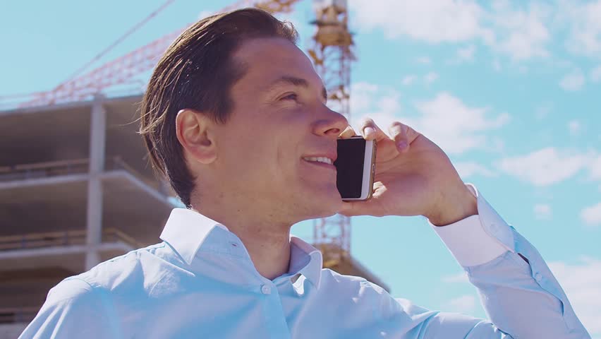 Business person standing in front of construction site. Office building and crane background. Development, real estate and investment concepts.