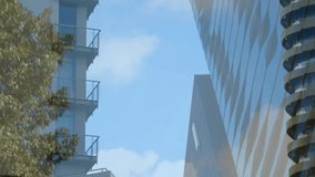 Animation of golden geometric shapes over low angle view of skyscrapers with clouds in sky. Digital composite, multiple exposure, buildings, architecture, development and city concept. - Powered by Shutterstock - Get 15% off with code: PIKWIZARD15