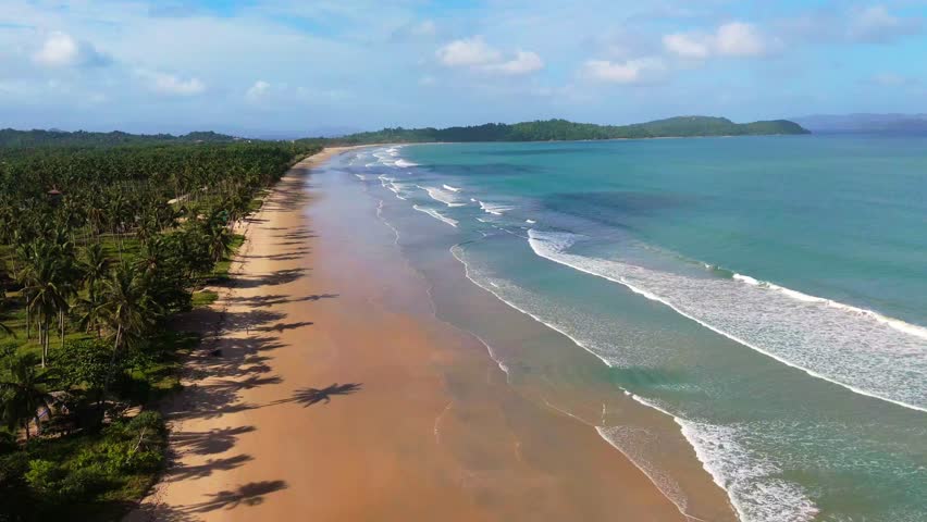 A cinematic drone shot of San Vicente Long Beach, capturing its vast 14.7-kilometer stretch of pristine sand and turquoise waters in Palawan, tropical paradise in Philippines