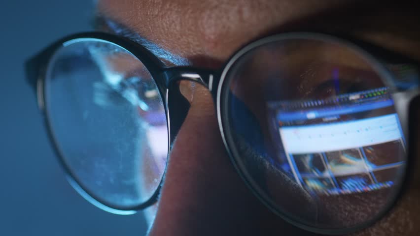 Close up of male face in glasses with reflection of digital gallery and computer interface. Concept of content browsing media selection online work digital screen technology and visual data processing