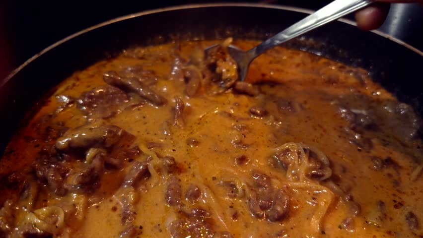 Cooking Beef Stroganoff In Frying Pan, Traditional Meat Sauce Preparation In Skillet With Spoon, Gourmet Beef Stroganoff Recipe Process, Delicious Meat Sauce Simmering In Kitchen, Homemade Beef Stroganoff Dinner, Culinary Meat Sauce