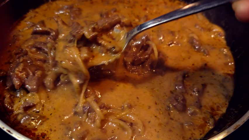 Cooking Beef Stroganoff In Frying Pan, Traditional Meat Sauce Preparation In Skillet With Spoon, Gourmet Beef Stroganoff Recipe Process, Delicious Meat Sauce Simmering In Kitchen, Homemade Beef Stroganoff Dinner, Culinary Meat Sauce
