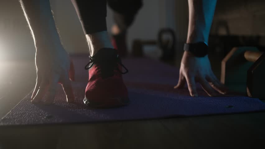 Young Athletic Man Doing Yoga Stretches On A Floor At Home In The Evening With Dramatic Light