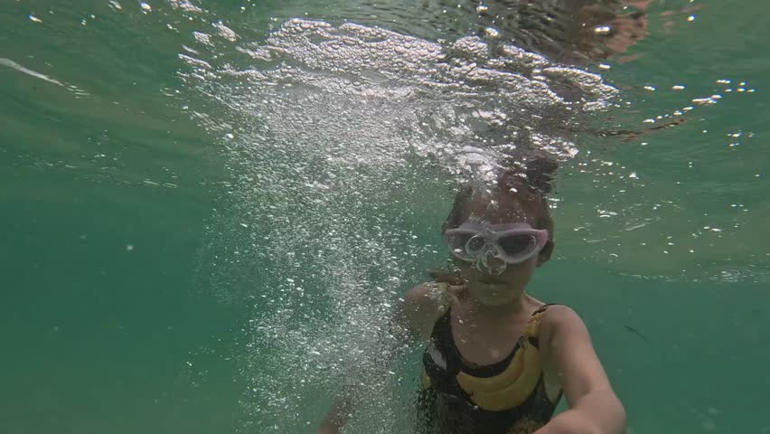 Little girl diving in shallow ocean water