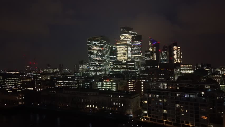 Establishing aerial view of London at night. Beautiful illuminated skyline of the capital of the United Kingdom