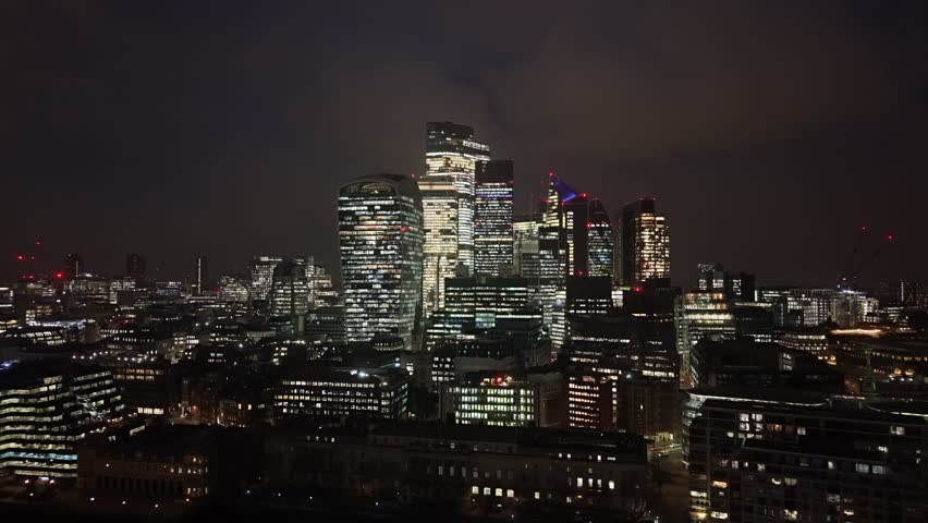 Establishing aerial view of London at night. Beautiful illuminated skyline of the capital of the United Kingdom