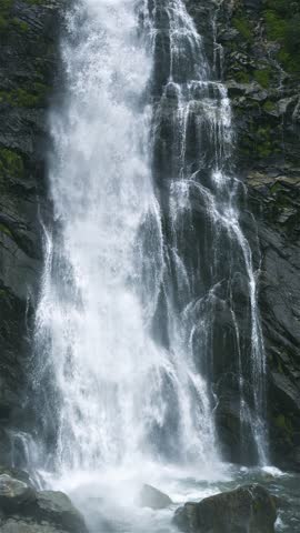 Water Falling Over Dark Rocks in Mountain Stream Waterfall, Vertical Nature