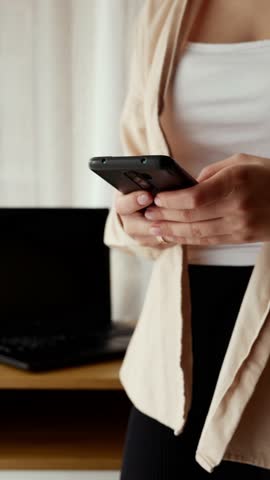Close-up of female hand holding smartphone, modern technology concept.