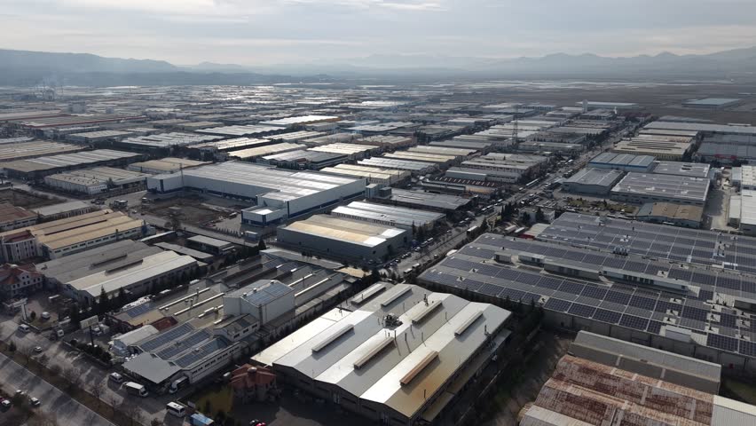 Aerial view of Kayseri Organized Industrial Zone with Mount Erciyes in the background, showcasing large scale manufacturing facilities and industrial infrastructure in central Turkey.