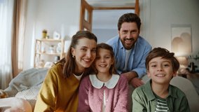 Laughing family members chatting online sitting sofa pov video closeup. Four people smiling looking webcam together. Happy parents siblings enjoying virtual conversation spending cozy weekend at home - Powered by Shutterstock - Get 15% off with code: PIKWIZARD15