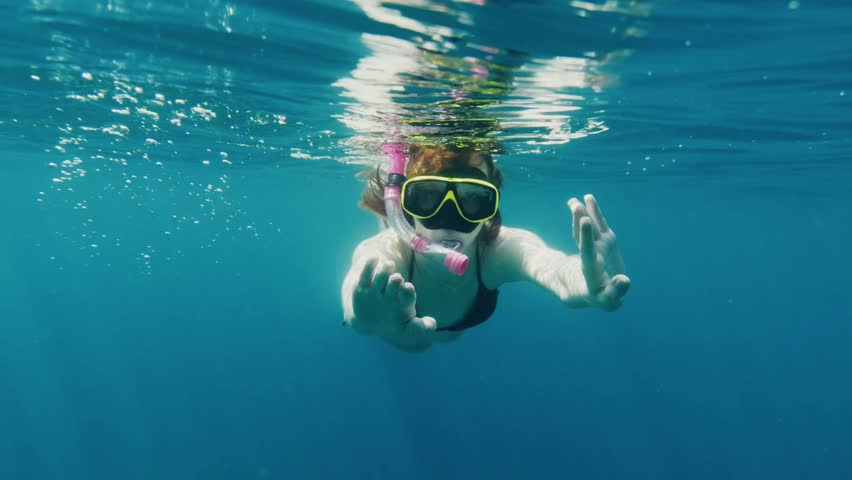 Young woman swimming underwater while snorkeling
