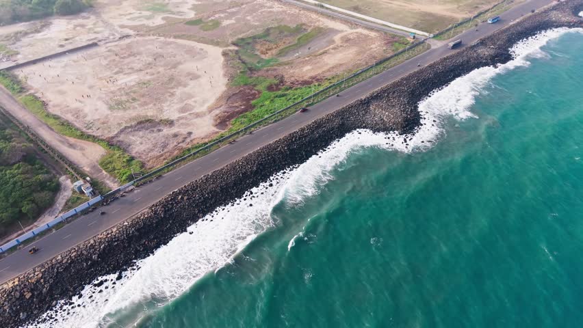Aerial View of Coastal Highway Along Ocean Waves and Rocky Shoreline