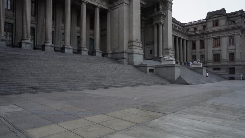 Camera slowly tilts up revealing a neoclassical building called "Palacio de Justicia" which is the seat of the supreme court of Peru. It