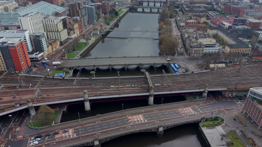 Aerial drone flyover of the River Clyde and Glasgow Central railway bridge in Glasgow city centre, Scotland.