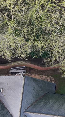 Vertical format top-down drone pan over Crinkle Crankle serpentine wall and gardens below, in Wheathamstead, Hertfordshire
