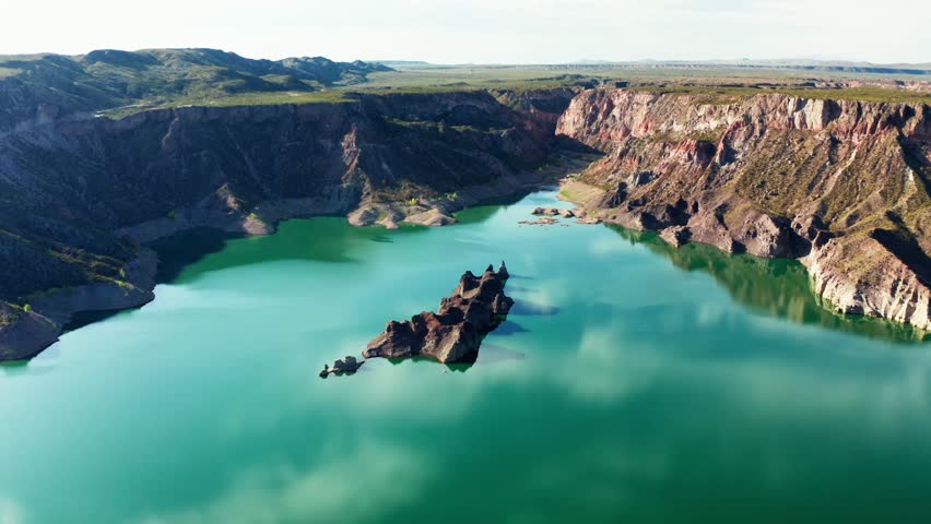 Aerial of turquoise water winding through rocky canyon at Canon del Atuel, Mendoza Argentina, picturesque cloudy reflections