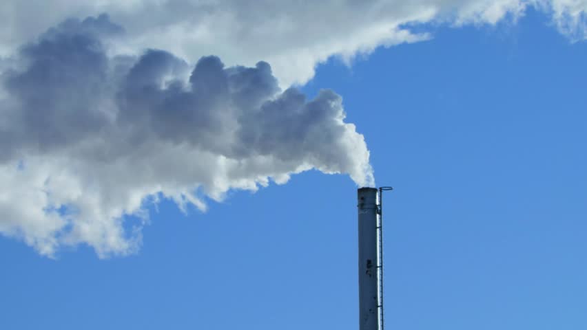 Smoke coming out of a factory chimney against a blue sky. Steam coming out of a chimney. Contrast. Nature and man.