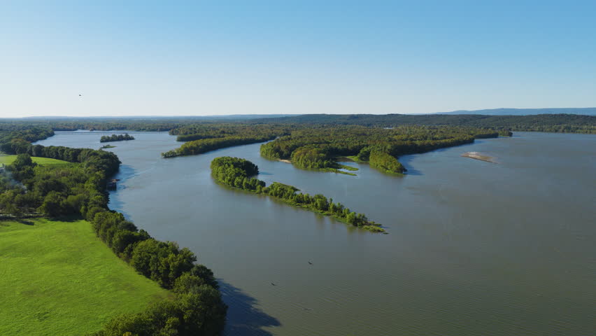 Wide river bend surrounded by wetlands and open green landscape in rural Cane Creek Recreation Area Arkansas, aerial pullback