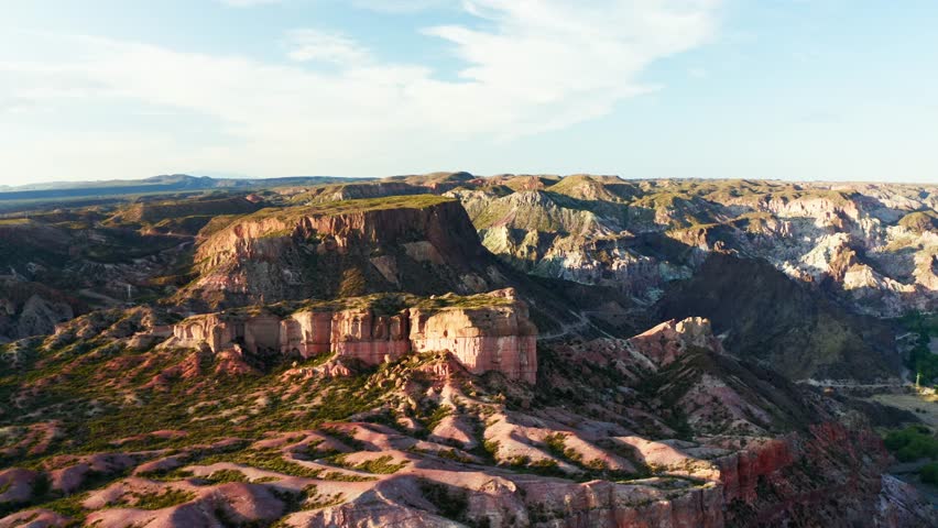 Sweeping aerial orbit sunlit canyon ridges and rocky plateaus, Canon Del Atuel, Mendoza Argentina