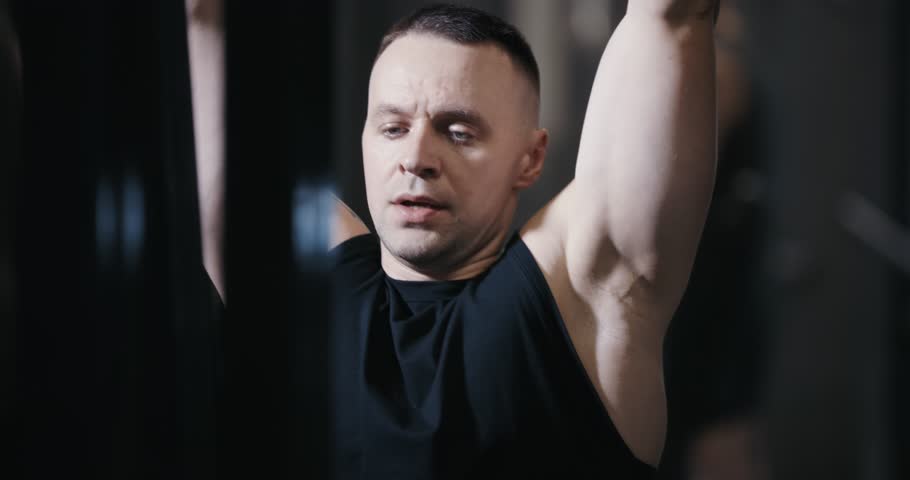 A man doing machine lat pull down exercise pumping his muscles in the gym
