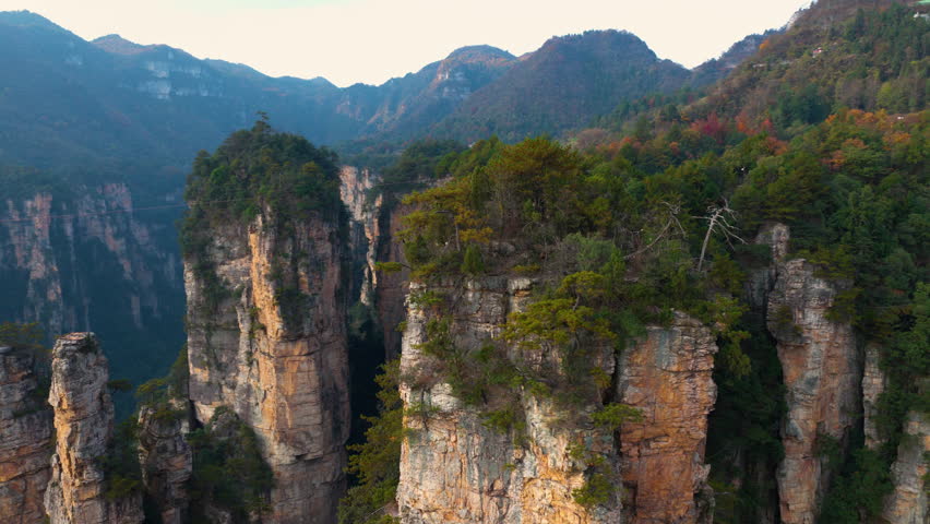 Lush Greenery Clinging To The Vertical Stone Cliffs Of Zhangjiajie National Forest Park In Hunan Province, China. Aerial Shot