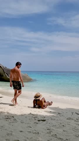 Friends enjoy a serene day at the beach on the Similan Islands in Thailand. Crystal-clear waters and soft sand create a perfect tropical getaway. Ideal for relaxation and adventure seekers.