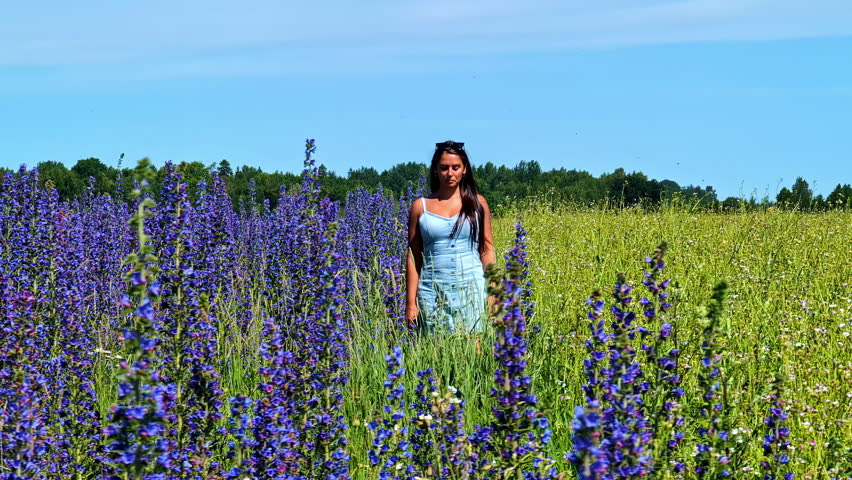 Young brunette woman walking on a field of Viper