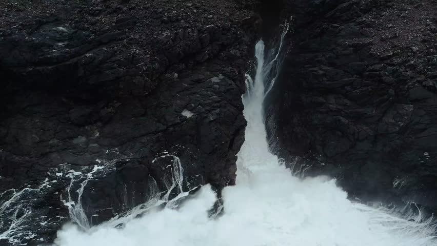 Drone shot of Atlantic waves breaking over volcanic rock on the Isle of Lewis.