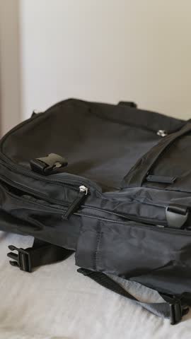 Travel ready moment: mobile and passport placed in cabin backpack, bag closed, and carried away. Vertical clip for modern lifestyle and weekend escape.