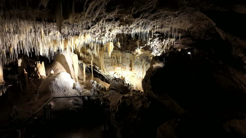 Illuminated Underground Lake Cave With Stalactites, Stalagmites and Reflective Cave Pool in Limestone Cavern, Western Australia