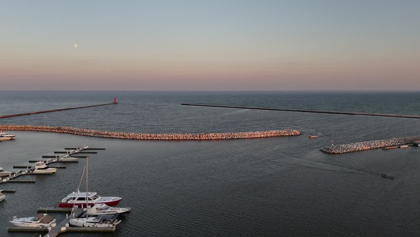 Aerial of Sheboygan Wisconsin USA at dusk on the shore of Lake Michigan.  Early Fall evening, rising drone shot under moon.