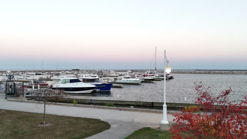 Aerial of Sheboygan Wisconsin USA at dusk on the shore of Lake Michigan.  Early Fall evening, slowly rising above boats.