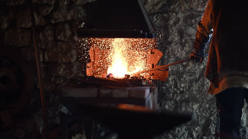 A Viking blacksmith with a white beard and braided hair works intently at a forge, hammering glowing metal on an anvil, with flames flickering in the background of a stone workshop cinematic slow