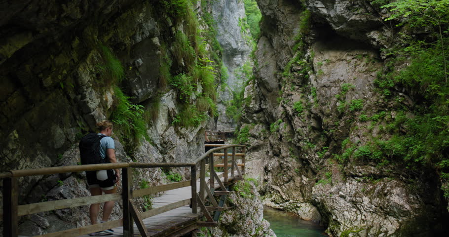 Hiker Walking Along Wooden Boardwalk Through Vintgar Gorge Slovenia