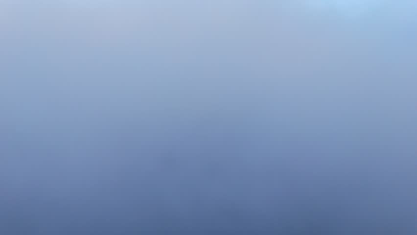 Wide aerial scene of thick fluffy clouds forming a sea below, calm blue sky with layered cloud bands and soft daylight near the horizon, ideal for dreamy travel and background visuals.