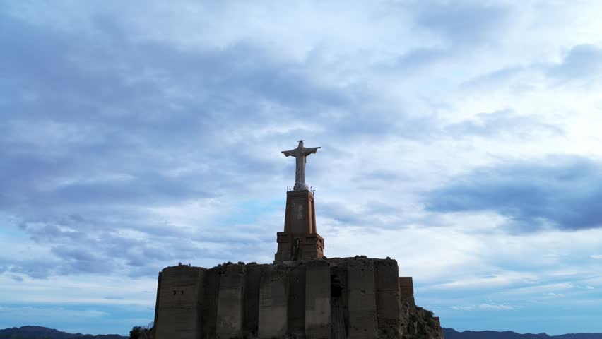 Storm clouds over the Christ of Monteagudo statue, Spain. Aerial drone, low-angle view, copy space