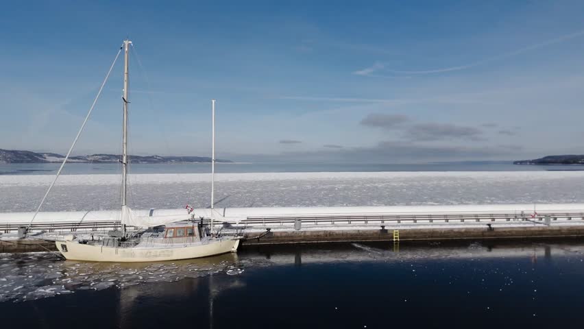 Tranquil Winter View of Frozen Lake Dock with Sailboat
