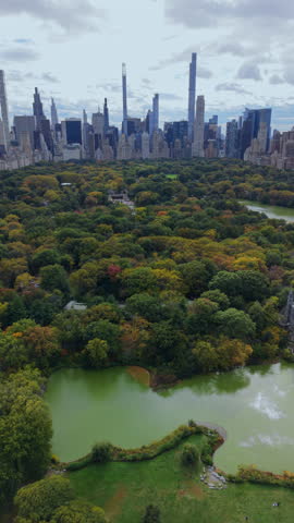 Aerial view of Central Park reservoir surrounded by autumn trees with Midtown Manhattan skyline beyond, New York City, New York, iconic urban park and city skyline composition