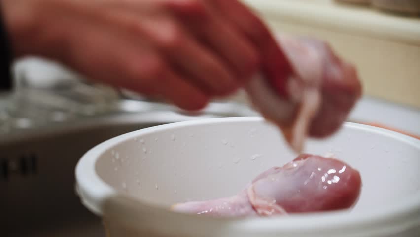 Preparing chicken legs for baking in sauce in the kitchen