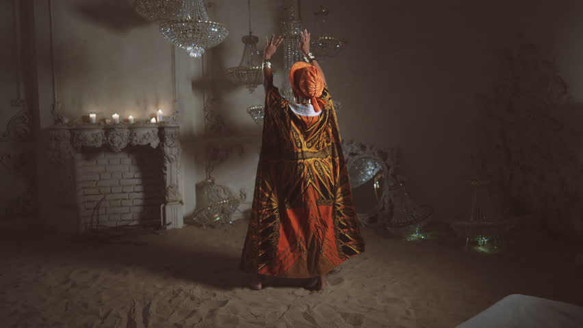 Beautiful african woman dancing on sand in amazing studio, soul of desert. Traditional african gown and ethnic music, unique dance performance, save heritage and culture of Africa, full-length shot