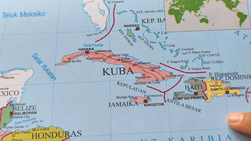 Hand pointing at a map of Cuba. Illustration of studying geography, analyzing places and routes. Cuba is a country located in the Caribbean, North America.