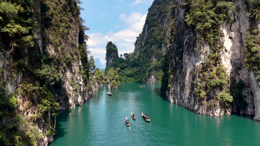 Journey through the stunning landscapes of Khao Sok, Thailand, where vibrant emerald waters meet towering cliffs, inviting adventure and tranquility amidst natural beauty.